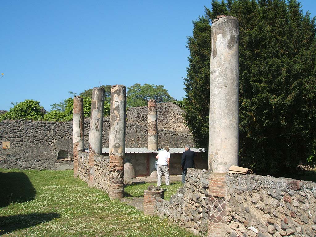 V.5.3 Pompeii. May 2005. Room 7, looking north-west at peristyle and columns. 
In BdI, 1890, various inscriptions of the gladiators are listed, including which column they were found on.
The columns in the photo above, would have been numbered 3, 4, 5 and 6, along the south side.
Number 2 would have been the first column on the west side, near the figures in the photo.
See Bullettino dell’Instituto di Corrispondenza Archeologica (DAIR), 1890, p. 25-39.
