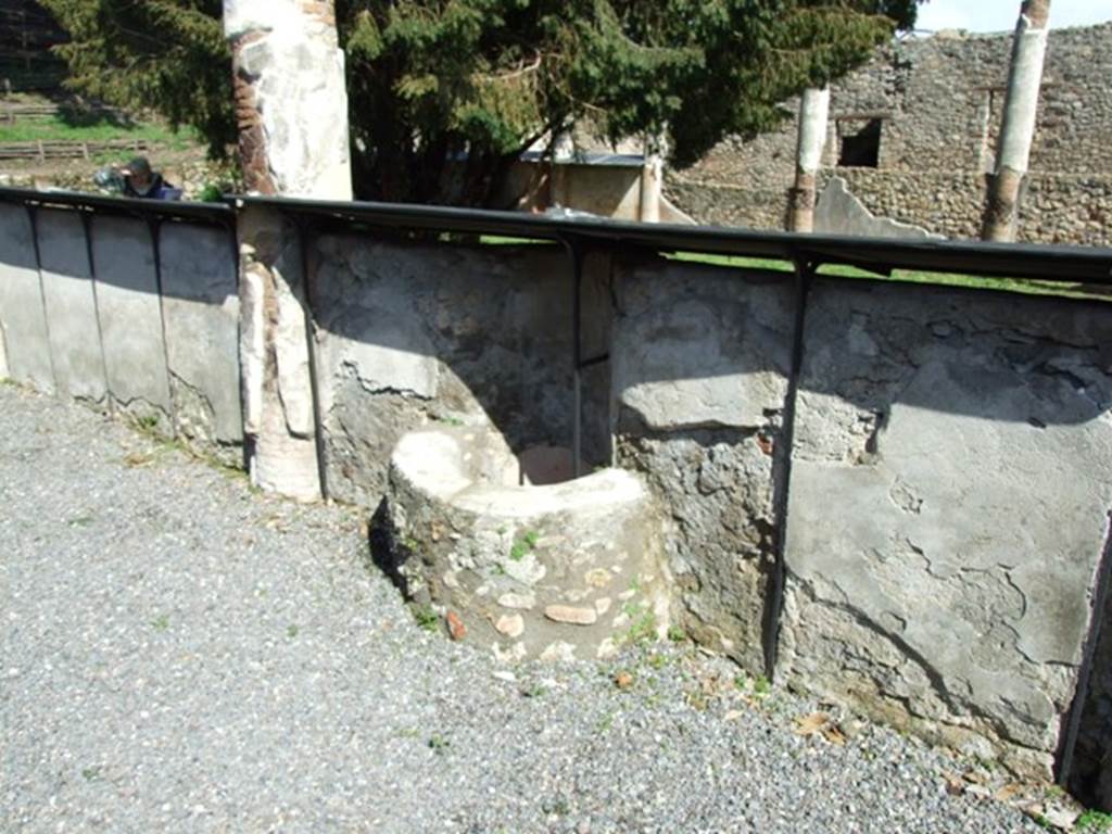 V.5.3 Pompeii. March 2009. Room 7, looking north-east along outer side of west peristyle wall, with puteal.