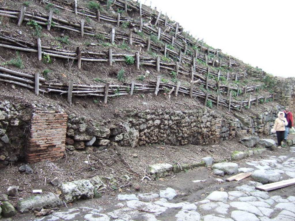 V.6.4 Pompeii, (on left). December 2005. 
Unexcavated doorways of east side of Via del Vesuvio, with V.6.3 Pompeii, on right.

