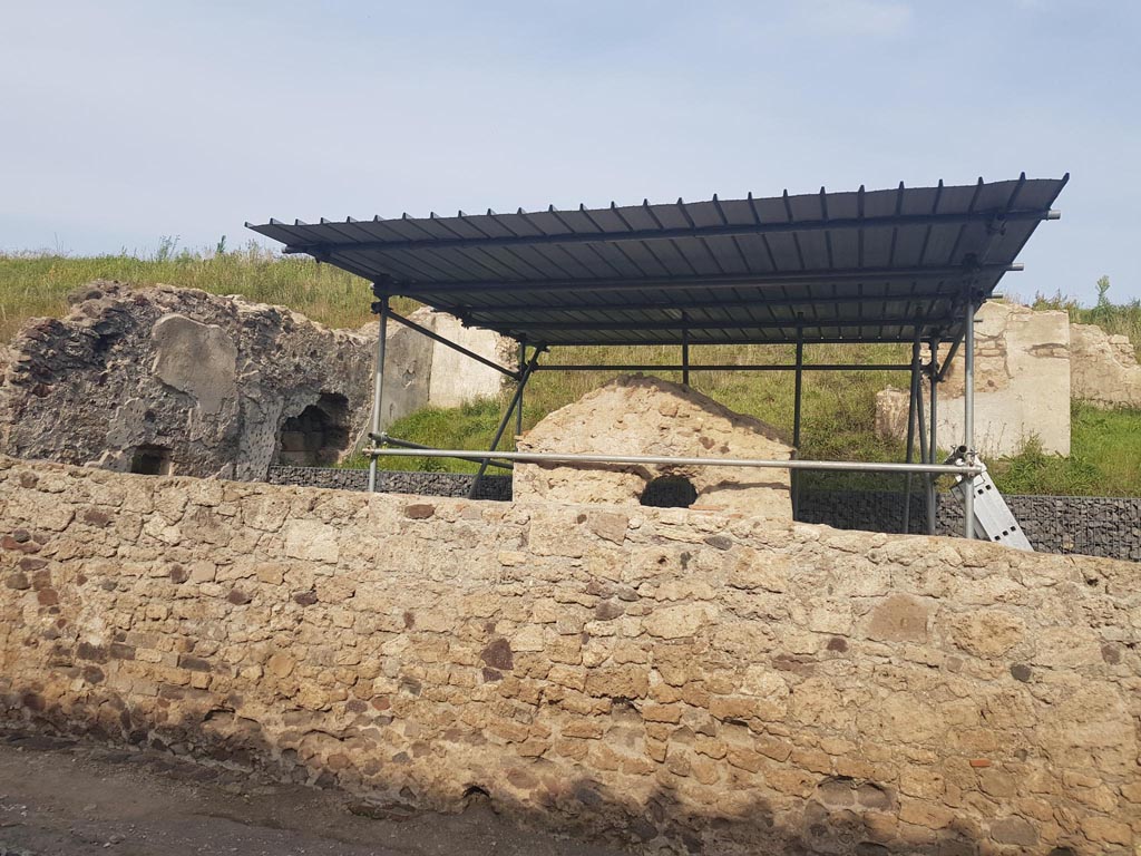 V.6.7 Pompeii. October 2022. Looking east on Via del Vesuvio towards rear of lararium. Photo courtesy of Klaus Heese.