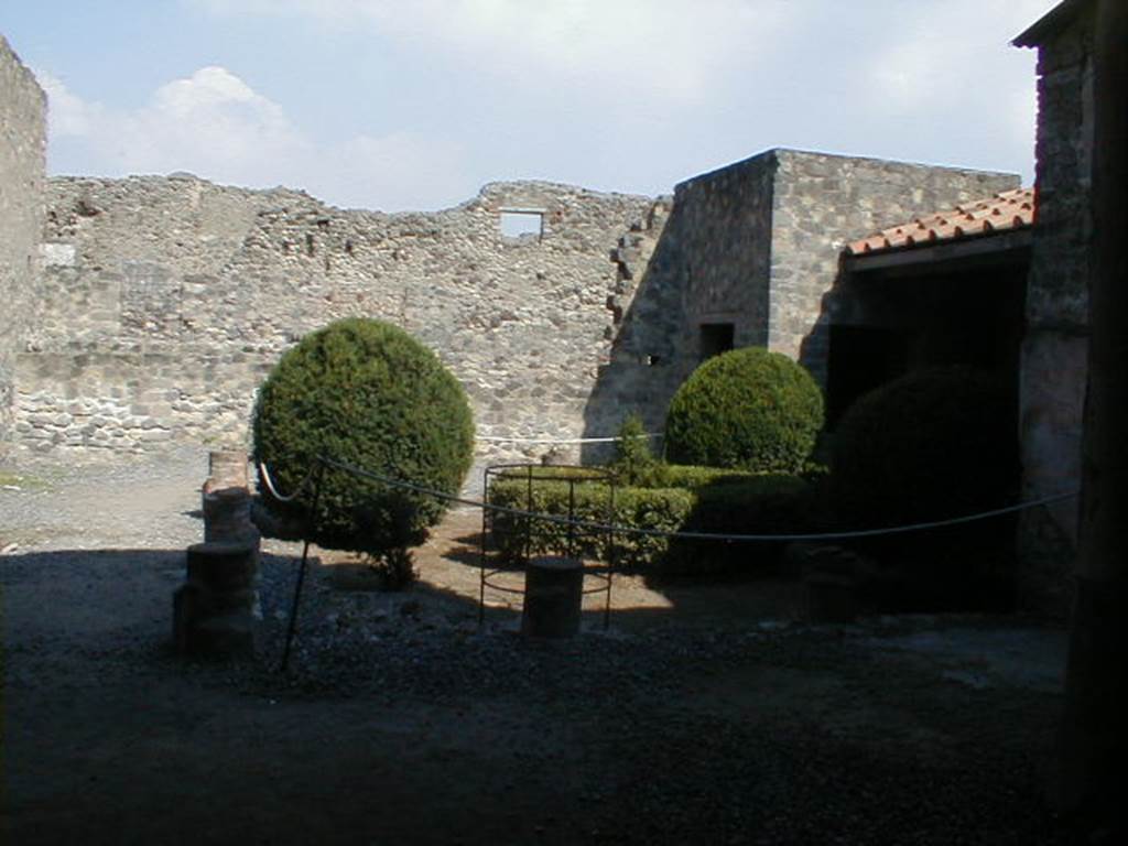 VI.2.4 Pompeii. September 2004. Looking east across portico of small garden. This was originally a three sided peristyle. It was destroyed by a huge bomb in September 1943. It was reconstructed in 1970-71 based on an 1824 plan by Mazois. It should be noted that  apart from the west side, the house was entirely destroyed by the bombing during the night of 14/15th September 1943.  According to Laidlaw, the roof, the south apartment, and the portico behind the main house block are almost completely modern reconstructions made in 1970-71. See Garcia y Garcia, L., 2006. Danni di guerra a Pompei. Rome: L’Erma di Bretschneider. (p. 66-74)


