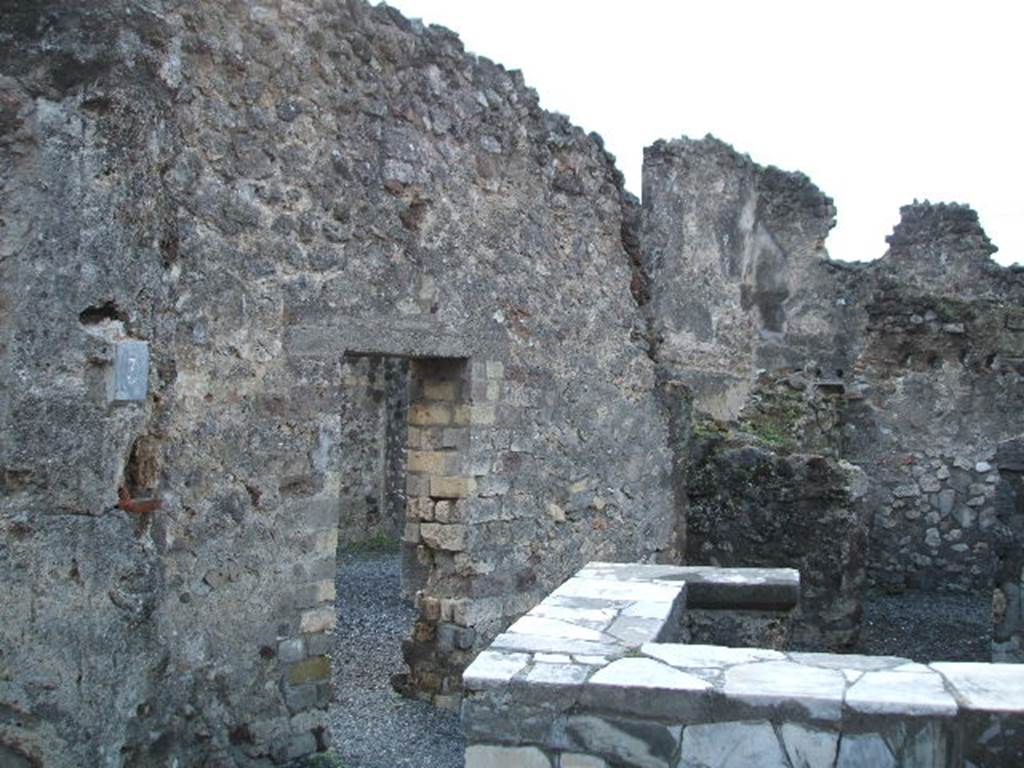 VI.4.3 Pompeii. December 2004. Looking west from entrance, across counter and towards linking doorway to VI.4.4. According to Boyce, in the west wall of the room with the counter were the ruins of a niche. Its walls were coated with white stucco and decorated with coloured spots. Its floor was a projecting tile.
See Boyce G. K., 1937. Corpus of the Lararia of Pompeii. Rome: MAAR 14. (p.45, no.150).
According to Garcia y Garcia due to the bombing, the niche to the west of the thermopolium has sadly disappeared. Also lost was the recess, perhaps for a bed in the south-east of the small rear room.
See Garcia y Garcia, L., 2006. Danni di guerra a Pompei. Rome: LErma di Bretschneider. (p.75)

