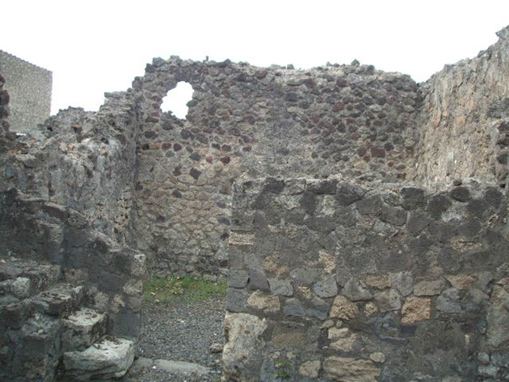 VI.4.5 Pompeii. December 2005. West wall of shop with steps on the left side of the doorway into rear room.