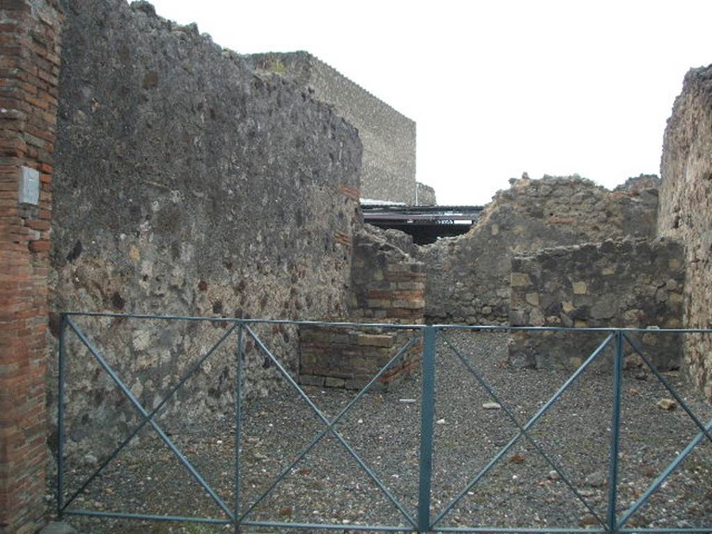 VI.4.7 Pompeii. May 2005. Looking west from entrance doorway, across large shop room to smaller rear room. On the left can be seen the two steps forming part of the steps to the upper floor.
