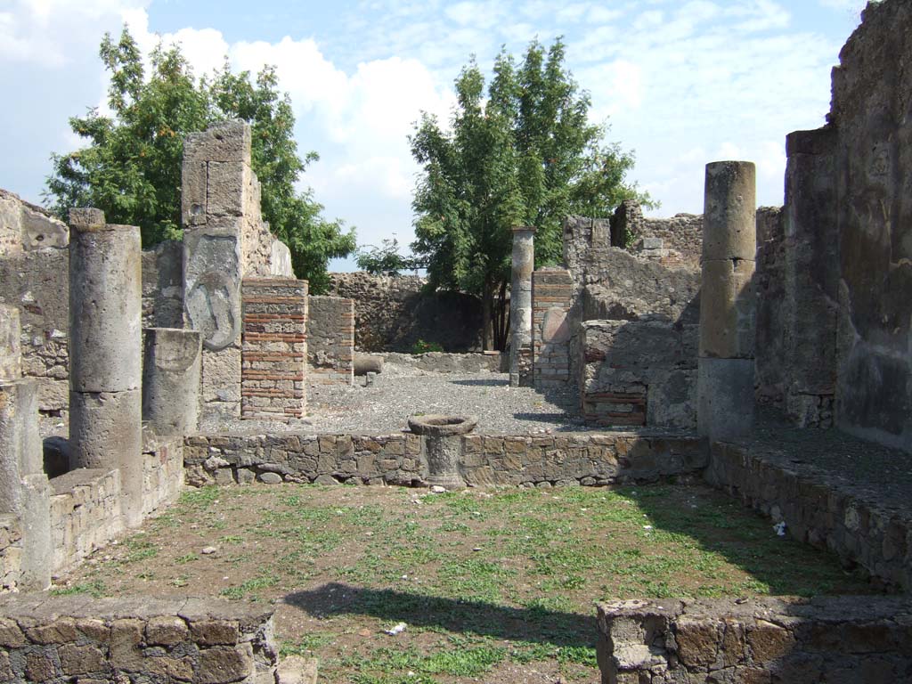 VI.5.4 Pompeii. September 2005. Looking east.
According to Jashemski, the six columns around the impluvium in the atrium (and according to Fiorelli) were joined by a low masonry wall.
This wall had a channel on top for plantings. It has now been restored without the planting space.
See Jashemski, W. F., 1993. The Gardens of Pompeii, Volume II: Appendices. New York: Caratzas. (p.125)
See Pappalardo, U., 2001. La Descrizione di Pompei per Giuseppe Fiorelli (1875). Napoli: Massa Editore. (p.54)
According to Breton, this house was remarkable for its impluvium with a hollowed out pluteus for planting flowers.
The beautiful columns around the impluvium were Doric, with their capitals more or less preserved.
See Breton, Ernest. 1870. Pompeia, Guide de visite a Pompei, 3rd ed. Paris, Guerin. 
