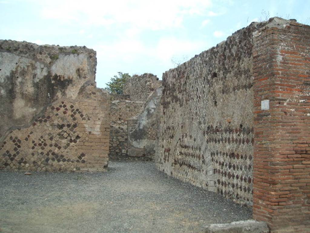 VI.6.21 Pompeii. May 2005. Looking north along east wall of shop towards doorway in north-east corner into VI.6.17. According to Stefani, this was a large corner sales shop for the bakery at its rear. On the west wall was a lararium painting with serpent, on the facing wall was a supposed cross in stucco. See Stefani, G. (2005): Pompei. Un Panificio: in Cibi e Sapori a Pompei e dintorni, (p.139).