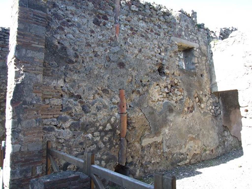 VI.7.5 Pompeii.  March 2009.  West wall with downpipe and site of VI.7.4 staircase to upper floor.