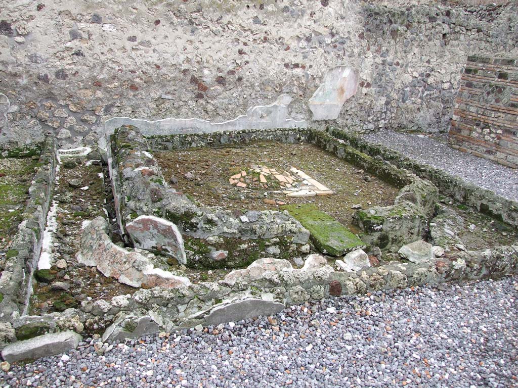 VI.7.23 Pompeii. December 2006. Remains of pyramidal fountain in courtyard.  
According to Garcia y Garcia, this area was badly damaged due to the bombing during the night between the 14th and 15th September 1943. 
The beautiful pyramid-shaped fountain was destroyed together with the partial destruction of the south wall including the beautiful garden painting with a painted statue of Diana. This was painted on the wall behind the fountain. Also destroyed were the dividing walls of the rooms on the west side of the area.
The damage was partially restored in 1976.
See Garcia y Garcia, L., 2006. Danni di guerra a Pompei. Rome: L’Erma di Bretschneider. (p.76)
See Jashemski, W. F., 1993. The Gardens of Pompeii, Volume II: Appendices. New York: Caratzas. (p.130-32).

