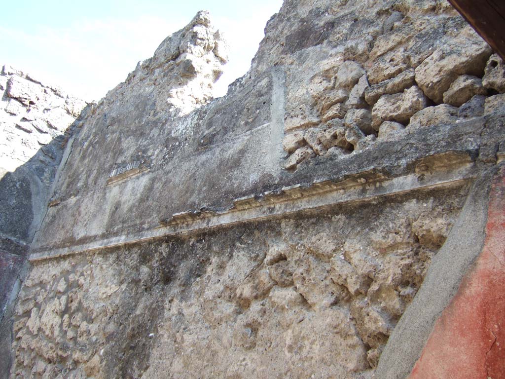 VI.7.25 Pompeii. September 2005. Remains of stucco decoration on south wall in cubiculum on north side of entrance corridor.