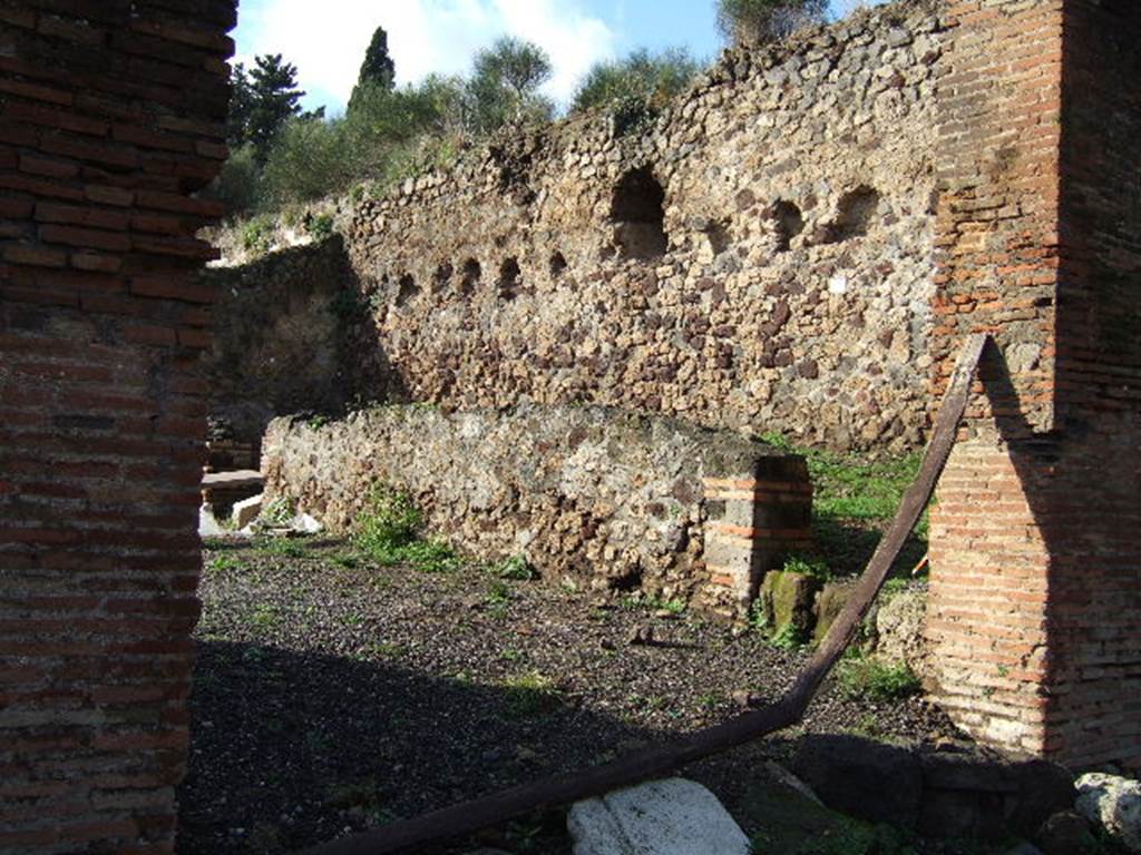 VI.7.26 Pompeii. December 2005. Looking west from entrance. According to Winsor Leach, this entrance led into a stable yard located under the wall, with a hay-loft above. A stair lead to a hayloft and the opening through which the hay was loaded can be seen. See Leach, E.W: The Social Life of Painting in Ancient Rome and on the Bay of Naples.
