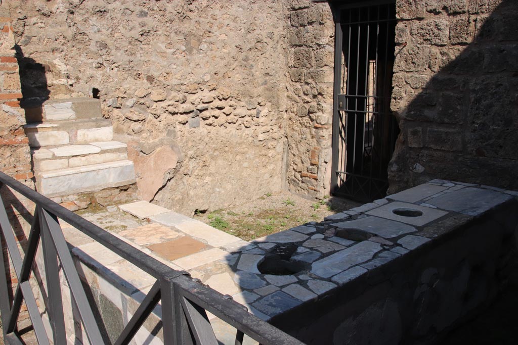 VI.10.1 Pompeii. October 2022. 
Looking north-east across bar-room, with display shelving, in upper left. Photo courtesy of Klaus Heese.
