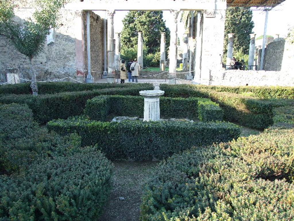 VI.12.2 Pompeii. December 2006. Looking north across first garden from rear of tablinum window, towards exedra and rear peristyle. According to Jashemski, this peristyle was enclosed on all four sides by a portico supported by twenty-eight columns covered with fine white stucco.
These columns were in the process of being repaired at the time of the eruption. In the middle of the garden was a base of a marble fountain, from which water jetted into a shallow pool. See Jashemski, W. F., 1993. The Gardens of Pompeii, Volume II: Appendices. New York: Caratzas. (p.145)
