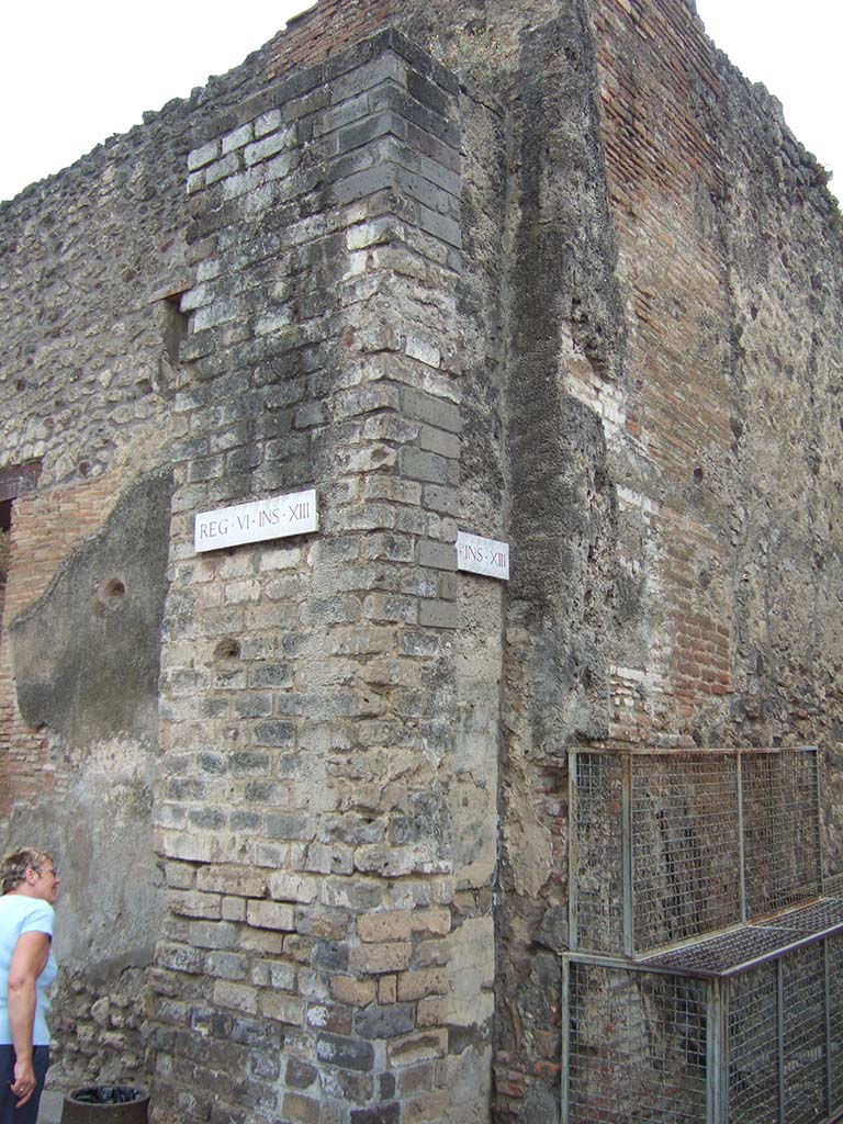 Water tower at corner of Vico di Mercurio and Vico dei Vettii by VI.13.16, May 2006.
Pipes were being laid at the time of the eruption and a large trench along the north side of the block had been exca¬vated. 
There were six pipes of different dimen¬sions, which were to keep the flow even and free of hiccoughs. 
The water tower or standpipe had a larger channel for pipes on its north face and a smaller one on its south face. 
It is built against the wall of a house for added support and stands across the pavement.  
Its pipe channels show heavy deposits of lime from leakage.  
See Richardson, L., 1988. Pompeii: An Architectural History. Baltimore: John Hopkins University Press. (p.56).
