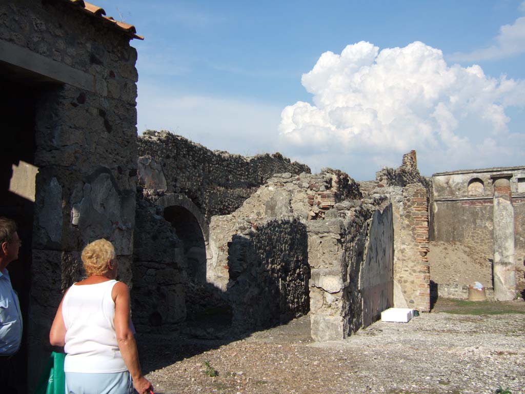 VI.13.19 Pompeii. September 2005. Looking north-east across atrium.
On the left is the doorway to a cubiculum on the north side of atrium.
Centre-left is the corridor/fauces leading to the rear of the house and to the doorway at VI.13.12.
The tablinum can be seen on the right.
