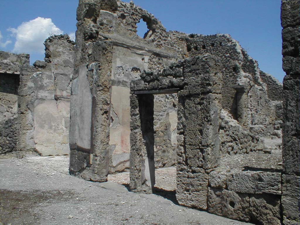 VI.14.12 Pompeii. May 2005. 
Rooms on east side of atrium. On the left, the doorway to the winter triclinium, the east ala, and then two doorways to cubicula.
