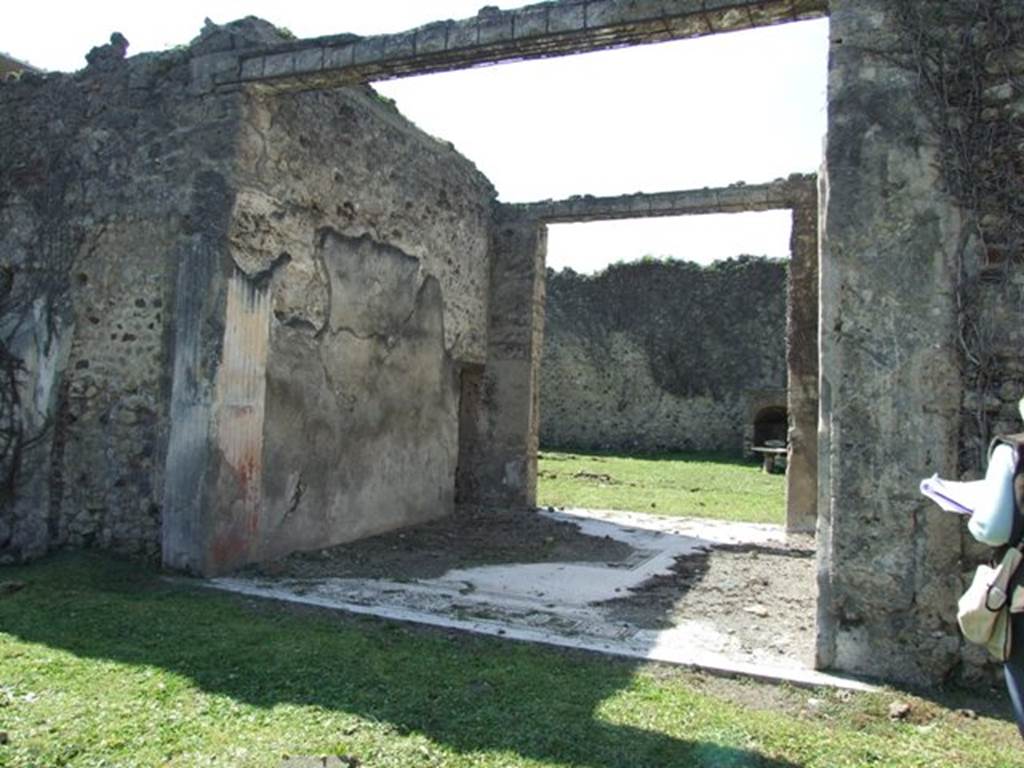 VI.15.5 Pompeii. March 2009. Room 7, south wall of tablinum, looking west. According to NdS, opposite the entrance doorway was the tablinum, with a good mosaic floor. In the middle of the floor was the usual rectangle indicating that this tablinum was also used as a triclinium. It was devoid of decoration, but there were some remains of the oldest decoration such as in the walls and doorposts, covered in grooved stucco, and with a red dado. See Notizie degli Scavi, January 1897, (p.23)
