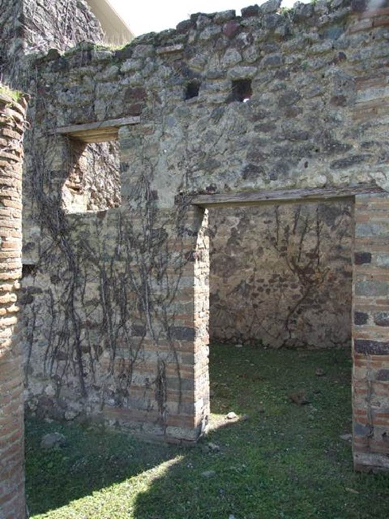 VI.15.5 Pompeii. March 2009. Looking across south portico to doorway to room 10.
According to NdS, this room had a window overlooking the garden. The mosaic floor not only covered the floor of the room but also the walkway of the south portico. According to Sogliano in NdS, this meant that previously the floor had belonged to a much broader room with a doorway turned to the east. This wall was later demolished and the smaller room 10 was formed, together with the south portico. This new smaller room had a doorway in its north wall and newly-built rustic walls. See Notizie degli Scavi, January 1897, (p.28)
