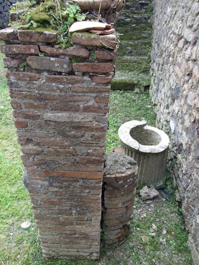 VI.15.6 Pompeii. March 2009. Room 7, west wall, brick pillar with half column, and puteal of yard. Looking south.