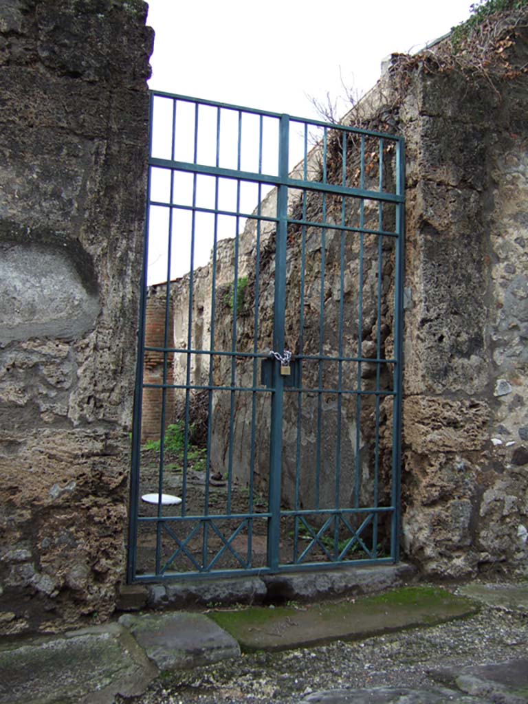 VI.15.6 Pompeii. December 2005. Entrance doorway, looking west.
According to NdS, this doorway led into a modest house.
The entrance doorway had limestone doorjambs. The fauces, or entrance corridor, preserved remains of coarse plaster.
Above the threshold of the doorway, the usual holes in the walls for the beam that would have strengthened the door when it was closed, could be seen.
See Notizie degli Scavi di Antichità, January 1897, (p.30).
