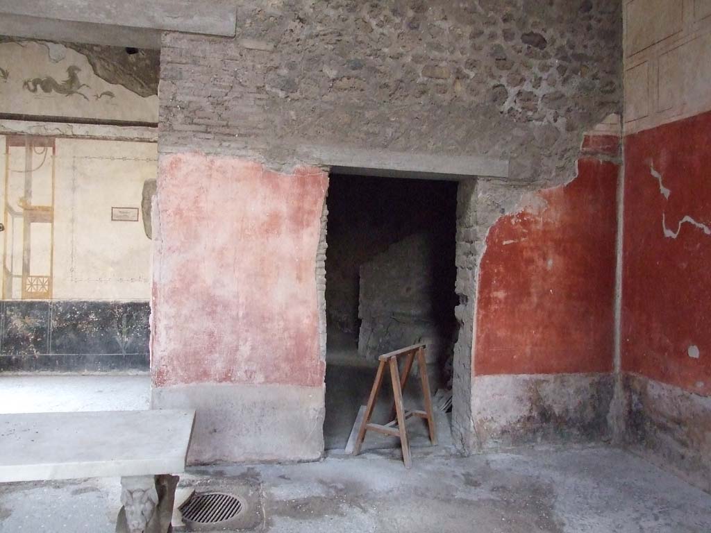 VI.15.8 Pompeii. December 2007. West wall of the atrium and doorway to kitchen area, on right.
At the foot of the dividing pillar between these two rooms, in the floor of the atrium, was the mouth of the cistern.
