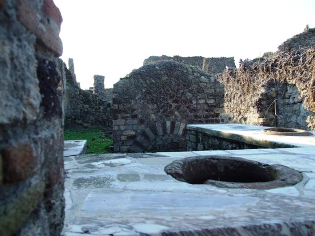 VI.15.15 Pompeii. December 2007. Looking west across counter, towards two doorways in west wall, into rear room. According to NdS, both the doorways would have had a wooden threshold.
