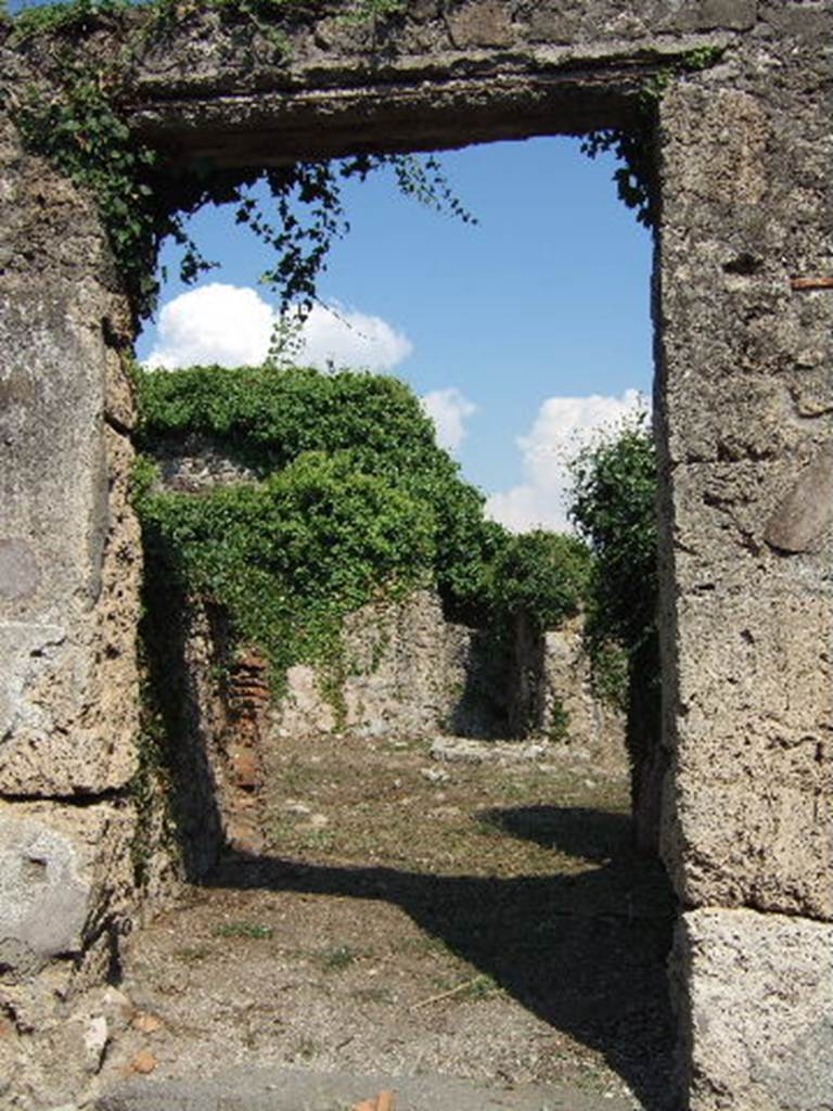 VI.15.20 Pompeii. September 2005. Entrance doorway, looking east. According to NdS, the wide entrance corridor was entered by a step at the (west) road end of it. The corridor had a high dado of black plaster. See Notizie degli Scavi, June 1897, (p.273)
