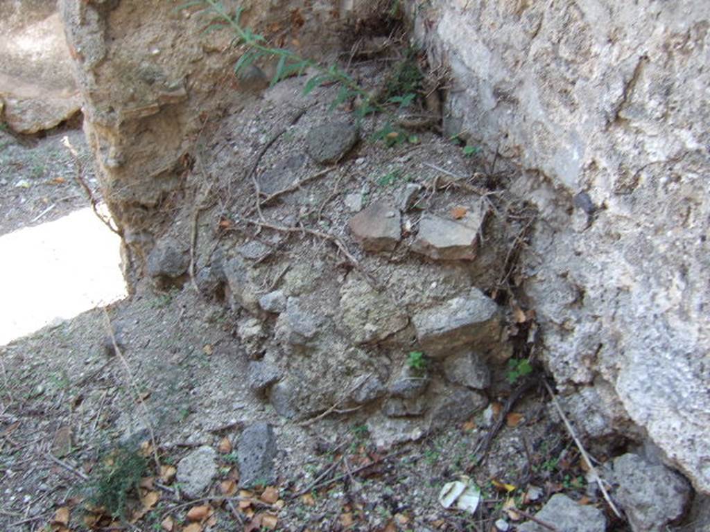 VI.15.21 Pompeii. September 2005. Remains of structure (?hearth) in south-west corner of kitchen, and doorway to entrance corridor.
