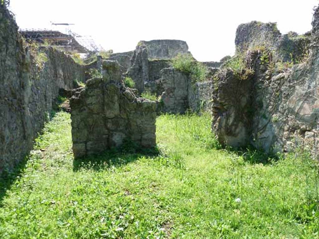 VI.16.11 Pompeii. May 2010. Looking west across shop to corridor to rear, on left, and rear room in north-west corner, on right. Originally, on the west wall between the corridor and the rear room was a lararium. According to Boyce, there was a ruined niche in the west wall, coated with white stucco bordered with red stripes. Red and green garlands were painted on the back wall of it. See Notizie degli Scavi di Antichit, 1908, p. 58. See Boyce G. K., 1937. Corpus of the Lararia of Pompeii. Rome: MAAR 14.  (p. 58, no.222).
