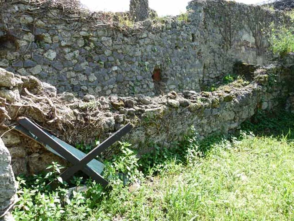 VI.16.11 Pompeii. May 2010. Remains of south wall of rear room, in foreground, with south wall of corridor in the background.