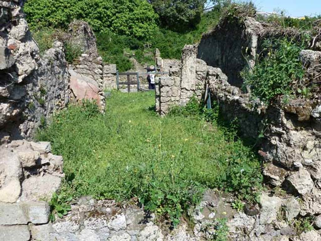 VI.16.11 Pompeii. May 2010. Looking east through site of window across large rear room, towards shop and entrance on Via del Vesuvio.
