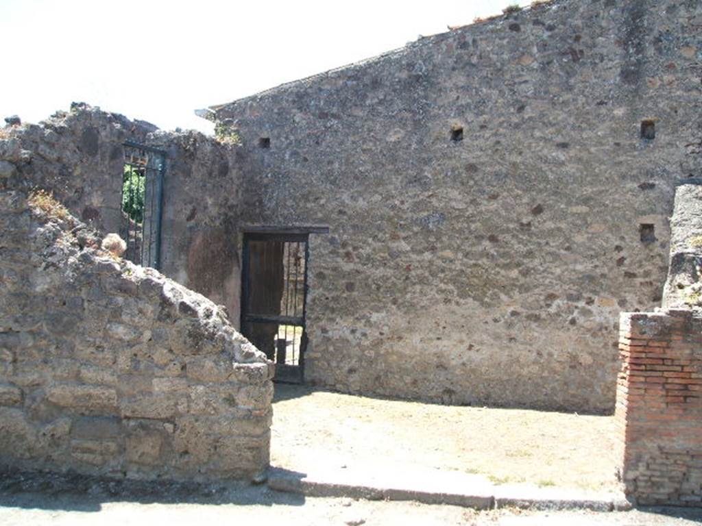 VI.16.19 Pompeii. May 2005. Looking west towards entrance doorway on Via Stabiana into room H, on plan of VI.16.26/27/19. On the left can be seen a doorway to room I, ala, and centre left can be seen the doorway to room H. According to NdS, on the left end of the west wall there was a small doorway that led from room H into room G, triclinium. Room H was of an irregular shape, and on its northern wall and partly on its western wall, preserved remains of large panels with a red background, offering instead on the southern wall, a simple coating of plaster (intonaco laterizio). See Notizie degli Scavi di Antichit, 1908, (p.188).
