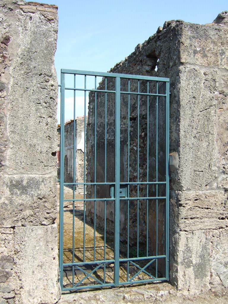 VI.16.26 Pompeii. May 2005. Entrance doorway, looking east.
According to NdS, this was the main entrance to the house, and VI.16.19 was the secondary entrance.
The two doorposts, made of limestone blocks which were covered with rough plaster, were high.
They really formed the entrance to a small vestibule (a).
This had a cocciopesto floor and walls faced with a high yellow dado, coated above the dado with rustic white plaster.
Below was the threshold of lava on which would have been embedded the wooden door-jambs and door-shutter.
See Notizie degli Scavi di Antichità, 1908, (p.183-192).
