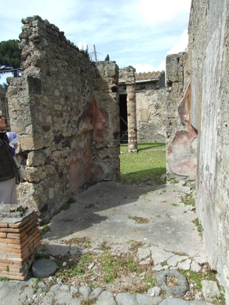 VI.16.27 Pompeii. March 2009. Room K, cubiculum. Looking north to atrium of VI.16.26.
According to NdS, it seems unlikely that this room was always open at both ends. On both the west and east walls the recess for the bed can be seen, which would be an unlikely place for a bed against an open north wall. The floor was of cocciopesto and the walls were divided into large red and yellow panels, devoid of ornamentation. The frieze was on a white background. It was only preserved in a small area, but showed arabesques and fantastic architecture, with a flying swan in the middle. The dado was red but did not show any decoration at all.
