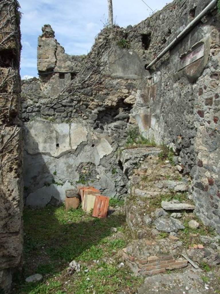 VI.16.27 Pompeii. March 2009. Room F, narrow storeroom on west side of staircase to upper floor. The masonry staircase was preserved to the first landing against the north wall, then it would have turned to the left. The wall to the right of the staircase conserved scant remains of the second style decoration.
.