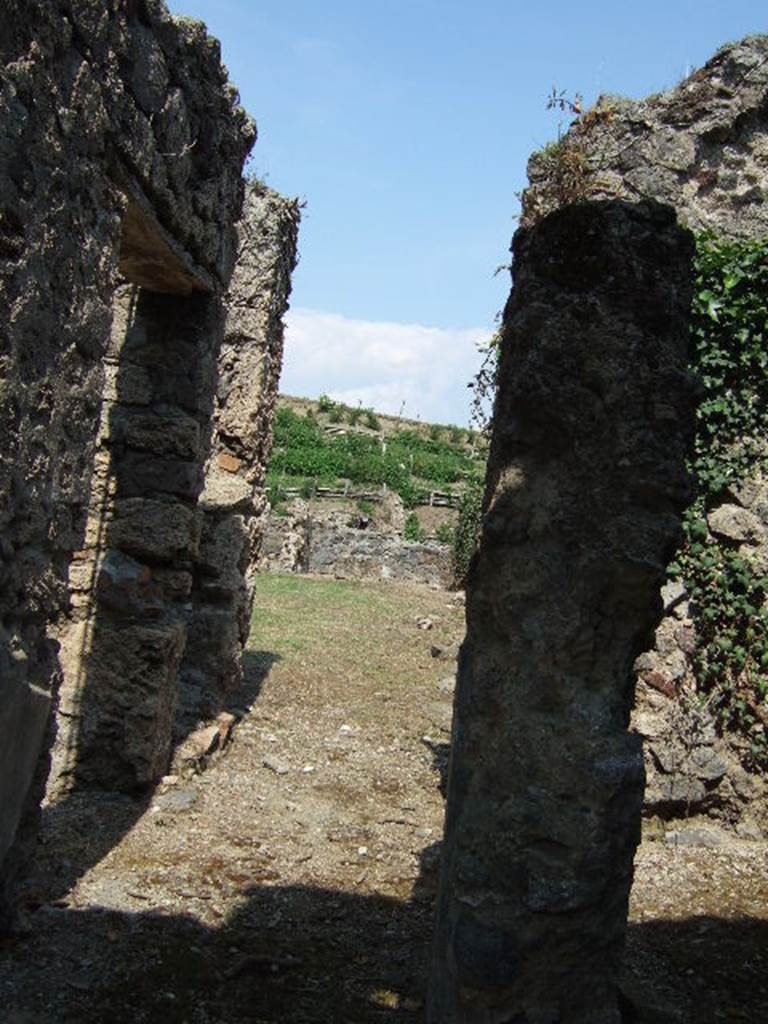 VI.16.27 Pompeii. May 2006. Looking east across entrance corridor or fauces. According to NdS, the floor was of cocciopesto and the walls, roughly painted, imitated a coating of marble slabs in black and white vertical streaks.
