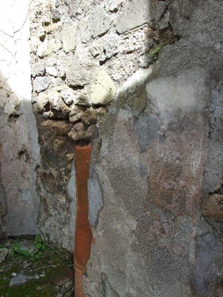 VI.16.28 Pompeii. March 2009. Room G, east wall with down pipe. According to Hobson, there are three down-pipes in this property, two of which may be associated with upper floor latrines. See Hobson, B. 2009. Pompeii, Latrines and Down Pipes. Oxford, Hadrian Books, (p.290, 294-5) According to NdS, in the east wall there was a terracotta down-pipe descending from the upper floor. In the height of the north wall, there were holes for supporting the beams of an upper mezzanine. See Notizie degli Scavi di Antichit, 1908, (p.278)