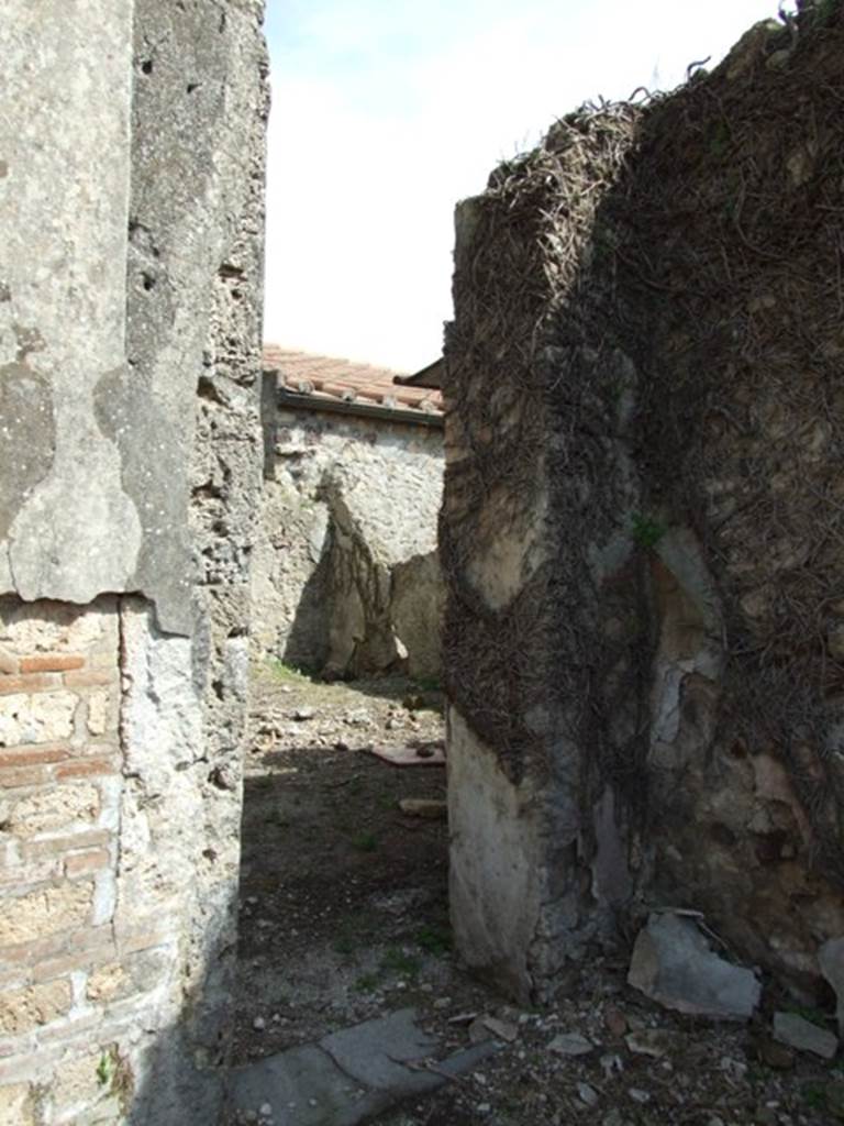 VI.16.28 Pompeii. March 2009. Doorway to room I, oecus. According to NdS, this doorway led to a rather spacious room on the south side of the tablinum. It had flooring made of mortar. Its walls had a white background with mediocre painted decoration, which was preserved in part on the east, south and west walls.  The principal space of the walls were divided into large panels, three on the east and south wall, and with two on the west wall, between them were columns with red bands, dividing the panels. Underneath was a dado with representations of plants, nothing remained of the frieze.
