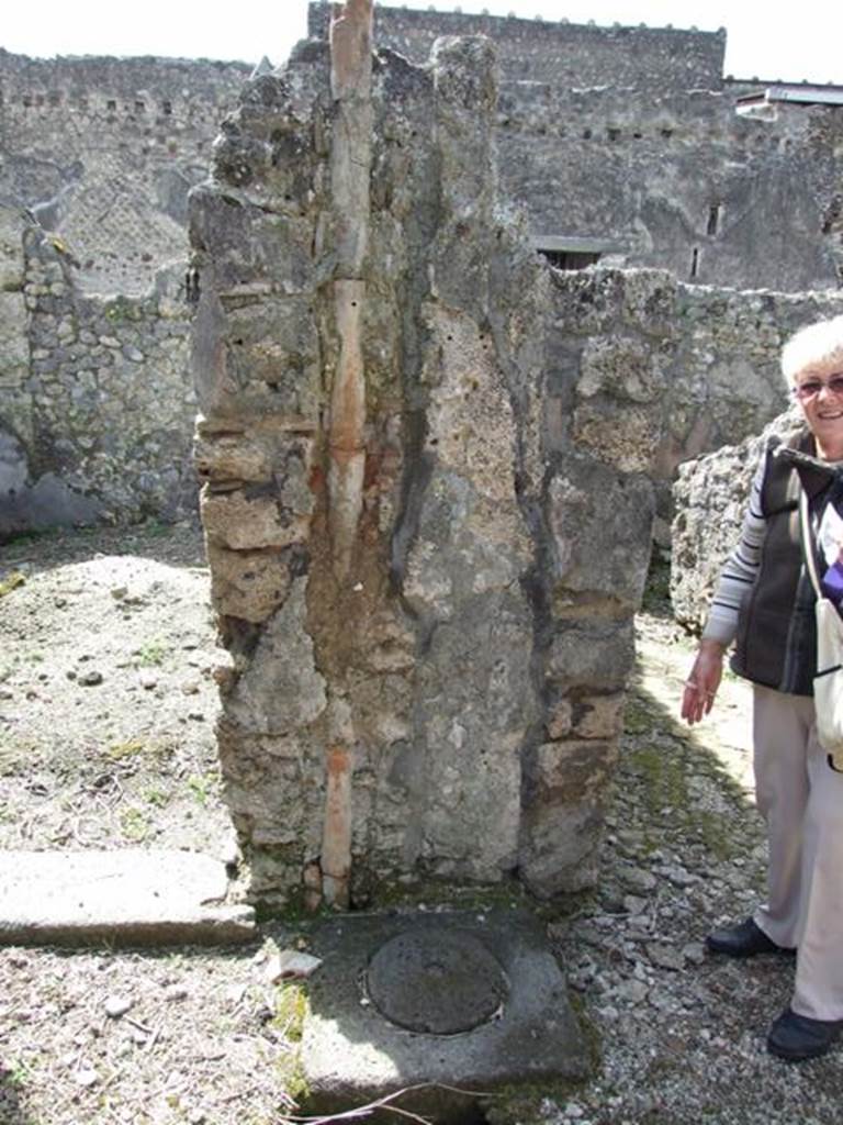 VI.16.28 Pompeii. March 2009. Room C, atrium.  Wall between doorway to room D and room A on west side of atrium, with downpipe to cistern (b).
