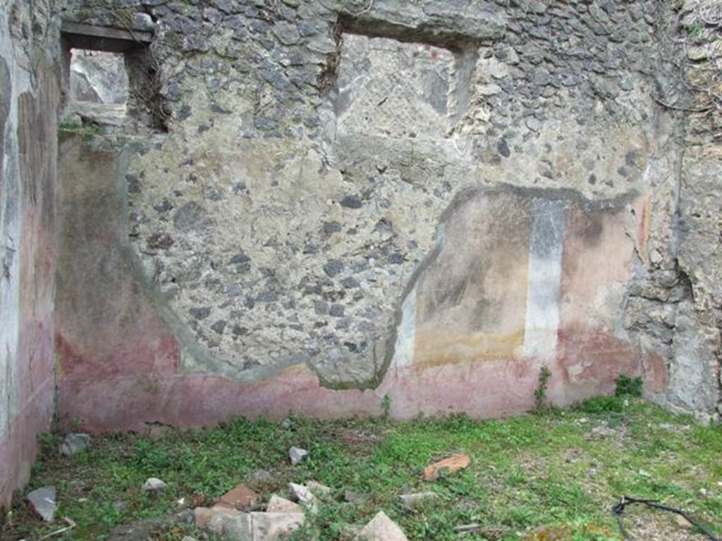 VI.16.29 Pompeii. March 2009. Room E, west wall decorated with two yellow central panels. According to NdS, this was a rectangular room, with floor of mortar and well-decorated walls. The long walls were divided into four panels, with three panels on the shorter walls.
The dado was decorated with the usual painted plants on a red background. The frieze had a white background, but hardly any of it remained, perhaps decorated with red horizontal bands. The central panels of the long walls as well as the only central panel of the short walls had a yellow background. The side panels were red, separated by wide white bands each containing a leafy and in bloom branch with numerous vertical twists. In the centre of each panel was a different species of bird, pecking, with small plants.