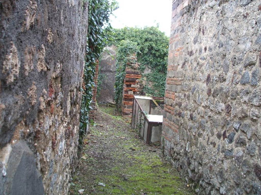 VI.16.35 Pompeii. December 2007.  Looking east from entrance doorway across fauces A towards atrium B, towards small corridor G leading to rear rooms. The rise in the floor of the corridor in the centre of the photo, would be the remains of the steps. On the right, on the east side of the atrium, the small tablinum can be seen.

According to NdS, the small atrium B was bare-walled and the floor was Opus signinum.
At the time of excavation it was noted for its impluvium a. This had a very high edge, faced with cocciopesto which had some pieces of encrusted marble in the upper horizontal surface. Running around the inside part was a decoration of  lines of yellow stucco in relief, and in each of the four corners, small palms, also in relief. The background consisted of a large disc of white marble and around it pieces of marble of various colours. The walls of the atrium were decorated with simple white plaster, the floor was of cocciopesto and formed a continuation with the floor of the fauces. At the extreme right of the northern wall of the atrium were three steps in masonry, plaster coated. Following these, a staircase also in masonry recessed between rooms E and H, leading to the upper floor.

On the east side of atrium B opened the full-width tablinum C. It had bare walls and its floor was Opus signinum, similar to the atrium and fauces. The left jamb would have been of wood, and it corresponded on the right with a brick pilaster. In the east wall of the tablinum would have been a wide window which would have had a wooden window-sill. This window gave light into room F, which was all faced with cocciopesto.

On the west side of the atrium was a doorway into room D, this doorway had wooden jambs and a threshold of masonry forming a step. The room did not provide anything notable, it had cocciopesto flooring and walls with a white background divided by red lines into large panels. In the west wall was a window overlooking Vicolo dei Vettii. 

On the north side of the atrium was a doorway which was to the left of the aforementioned stairs, this led into room E. The doorway had wooden jambs and it seemed also, a threshold of wood. The rectangular room had a floor of cocciopesto and walls with a high plinth of brick plaster. In the south wall a small window protruded into the atrium.

Room G was a rather narrow corridor, whose entrance from the atrium had a wooden threshold. In its eastern half it was only separated from room F by a low wall. In the corner of this low wall and the east wall, the mouth of a tank made of terracotta, covered in robust masonry was found, b.

Room H opened from the north side of corridor G, its doorway had a lava threshold and originally would have had wooden door-jambs. This room did not offer any other decoration other than the usual brick plaster plinth on the walls, and floor of cocciopesto. A pile of lime was in the north-west corner.  To the right of the doorway in the south wall, was a window into corridor G, and in the west wall was a room under the stairs. This room was transformed into an apotheca, as proved by the holes for the shelving supports. See Notizie degli Scavi, 1908, (p.359-363)


