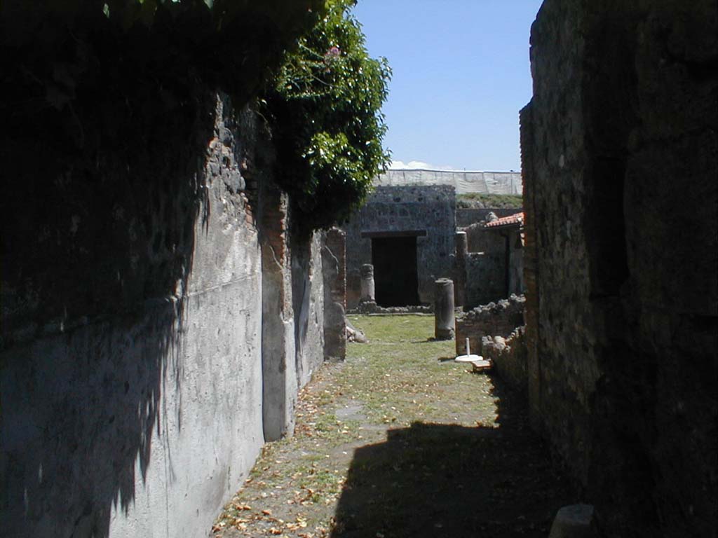 VI.16.36 Pompeii. May 2005. Looking east from entrance.
According to Garcia y Garcia, -
because of the night bombardment of 16 September 1943, this house suffered the destruction of the western ala of the portico and of 3 adjoining rooms.
This caused the loss of wall paintings in the IV style. 
At the moment of Garcia’s control for the RICA maps in January 1983, the house was in the course of restoration. 
See Garcia y Garcia, L., 2006. Danni di guerra a Pompei. Rome: L’Erma di Bretschneider. (p.96).
