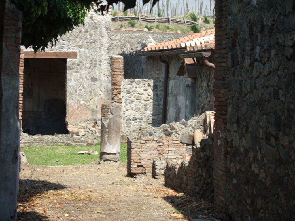 VI.16.36 Pompeii. December 2007. Looking south-east towards peristyle. According to Jashemski, the garden toward the rear of the house, was enclosed on the east, north and west by a portico supported by nine columns, including the two columns which are partly walled in, at the south end of the east and west walls.  The columns were connected by a low masonry wall, with a space in the top for plantings.  This wall, which was very low on the west, formed a step to permit entrance to the garden. The low wall was interrupted on the south end of the east side by the mouth of the cistern.  There was a gutter at the edge of the garden on the east, north and west.  Standing against the south wall of the garden was an aedicula shrine.  In front of the aedicula was a rectangular white marble table (0.75m high) with a travertine support. See Sogliano, Notizie degli Scavi di Antichità, 1908, pp. 364 and fig 1 (plan) on p.360.  See Jashemski, W. F., 1993. The Gardens of Pompeii, Volume II: Appendices. New York: Caratzas. (p.164).