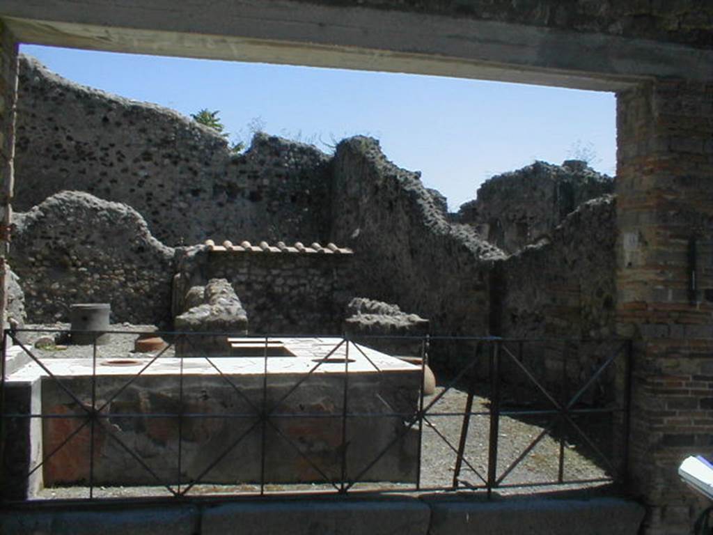 VI.16.40 Pompeii. May 2005. Looking south-east from entrance doorway towards corridor E on south side. The room F was lit by a window in the southern wall, and was reached by the corridor E. According to Boyce, in the room reached by the corridor leading from the bar-room, was a lararium painting. It was on a large panel on the west wall bordered with broad stripes, yellow at the sides, red at the top. Within were painted two serpents confronted at a cylindrical altar. The serpents were of a brownish colour and each had a red crest and beard, both larger on the one on the right. The altar was tiny in comparison with the serpents, and was painted in imitation of red and yellow marble. On the top of the altar were two eggs and a pine cone. Below the painted altar, a tile was embedded in the wall to hold the offerings. The background was profusely adorned with green plants and red flowers. Across the top of the panel was stretched a triple festoon, upon the middle of which perched a bird. See Notizie degli Scavi di Antichità, 1908, 370. See Boyce G. K., 1937. Corpus of the Lararia of Pompeii. Rome: MAAR 14. (p.59, no.230, and Pl.27,1)  See Fröhlich, T., 1991. Lararien und Fassadenbilder in den Vesuvstädten. Mainz: von Zabern. (L77, Picture 9,2 from the west and north walls)
.