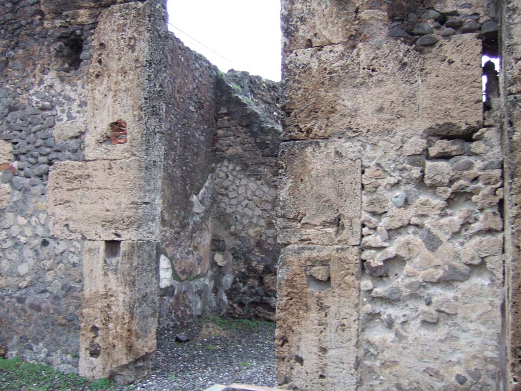 VI.17.13 Pompeii. December 2005. Doorway to first room on north side of atrium, triclinium.
According to Allroggen-Bedel, she could not locate rooms 11 and 12 of VI.17.10, but, she wrote -
“However, two rooms in the next door house (VI.17.12-13) meet the description of rooms nos. 11 and 12.
La Vega said that in the space described as no.12, he had discovered a “sotterraneo” (underground room/cellar, etc). 
The characteristics of the rooms– bed recess and sotterraneo, were both to be found next to the cellar stairs in VI.17.12.
The room described as no.11 is probably identical with the room next door (VI.17.13), where the remains of the yellow background central zone decoration was preserved.”
See Allroggen-Bedel - Die malereien aus dem Haus Insula Occidentalis 10, in Cronache Pompeiane II, 1976 (p.144-183).
