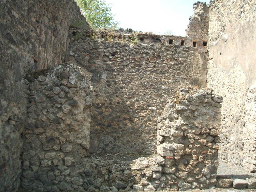 VII.1.20 Pompeii. May 2005. West wall of shop, with window and doorway to rear room.
According to Fiorelli, a painting of Bacchus accompanied by his panther, was found in this room in the middle of two obscene paintings.
See Pappalardo, U., 2001. La Descrizione di Pompei per Giuseppe Fiorelli (1875). Napoli: Massa Editore. (p.75)

“E poco innanzi con lo stesso sistema di escavazione orizzontale rinvenivasi a dodici palmi dal pavimento l’intero scheletro di un Ostiario con chiave di ferro nella sinistra mano, in cui aveva l’anello di bronzo ossidato, al quale quella chiave stava infilzata, giacente sul sinistro fianco in una stratificazione molto compatta prossima ad un angolo della bottega no.65.”
See Real Museo Borbonico, vol. 15, 1856, (p.12 of “Relazione degli Scavi di Pompei, da Marzo 1862 a dicembre 1855”).
(trans: And found a little further on with the same system of horizontal excavation, twelve palms (3.16 metres) from the floor, the entire skeleton of a man (Ostiario) with iron key in his left hand, in which he had an oxidized bronze ring, to which that key was attached, lying on the left side in a very compact stratification close to a corner of the shop at no.65.)

