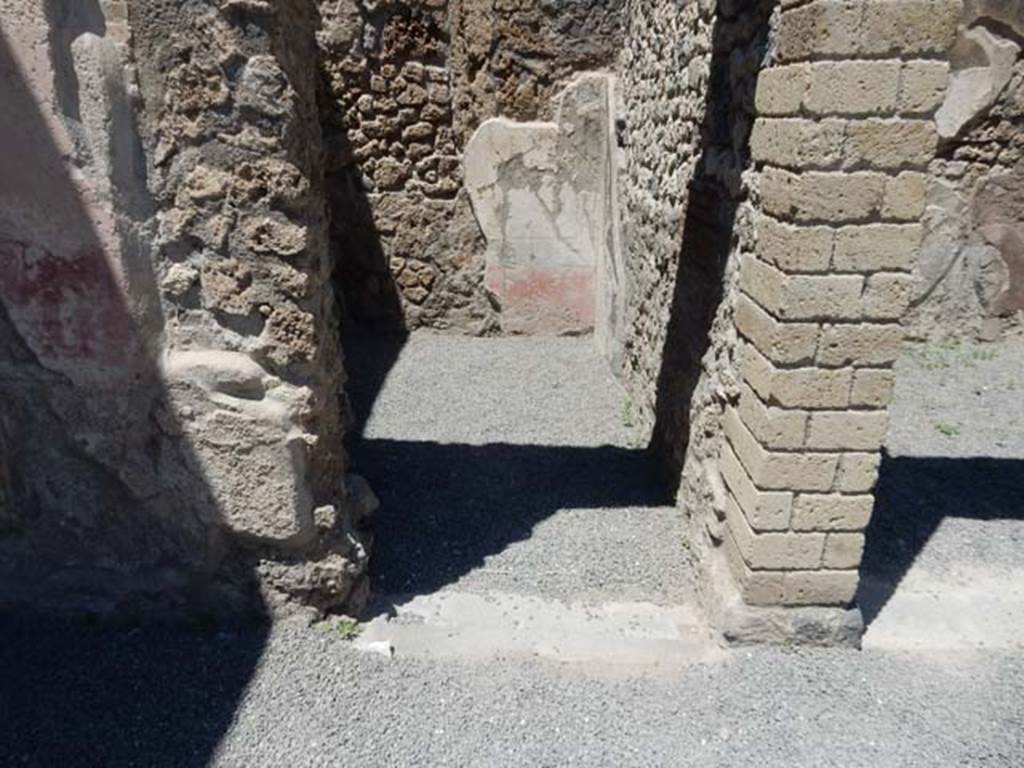 VII.1.25 Pompeii. May 2017. Doorway to small room 28 in north-west corner of atrium. Photo courtesy of Buzz Ferebee.
According to Niccolini –
The other two small rooms which give onto the atrium marked by numbers 7 and 9 (our rooms 30 and 28) were decorated with several paintings.
(see room 30 above) ……… while the room that was facing and corresponding to the ala across the atrium on its wall to the right, was a cubiculum 9 (our room 28). I point out the doors which would have closed it, whose vestiges are distinct on the threshold.
Like those of the ala, placed facing, the pretty walls of the cubiculum decorated with beautiful ornamentation painted over a white background in which among compartments of yellow, green, and red lines, and with several whirled patterns, there are various flying Cupids, as well as a Candelabra and an ideal architecture surmounted by a winged monster with horned dragon head, and with leonine paws.
(“Le altre due piccole stanze che dan sull’atrio segnate co’ numeri 7 e 9 ornate sono da svariati dipinti. (nostri ambienti 30 e 28).
(vedi room 30 sopra) ……………mentre l’ala che e sta rimpetto e che pur nell’atrio corrisponde, sul suo muro a destra, era un cubicolo 9 (nostro ambiente 28),
Io additano gli usci che lo chiudevano, le cui vestigie sono sulla soglia distinte.
Come quelle dell’ala, posta di faccia, son vaghe assai le mura di un tal cubicolo per leggiadri ornati sopra bianco fondo dipinti nel quale fra scompartimenti di linee gialle, verde, e rosse, e con svariati rabeschi, si veggono vari Amorini svolazzanti, oltre ad un candelabro e ad una ideale architettura sormontata da alato mostro con testa di cornuto drago, e con leonine zampe.”)
See Niccolini F, 1854. Le case ed i monumenti di Pompei: Volume Primo. Napoli, Casa numero 57, p.2.

