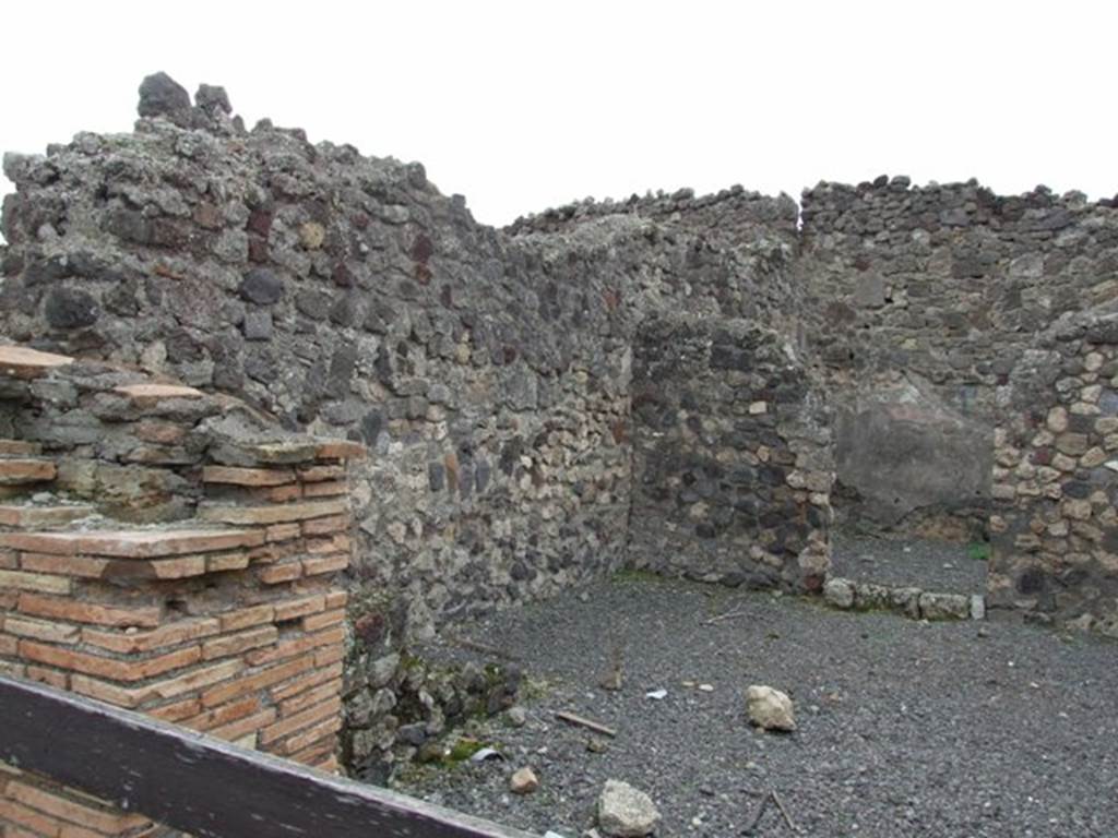 VII.1.34 Pompeii. December 2007. Entrance pillar of shop on the south side.  
Remains of stairs of VII.1.33 are to the left front next to the south wall of the shop.   
