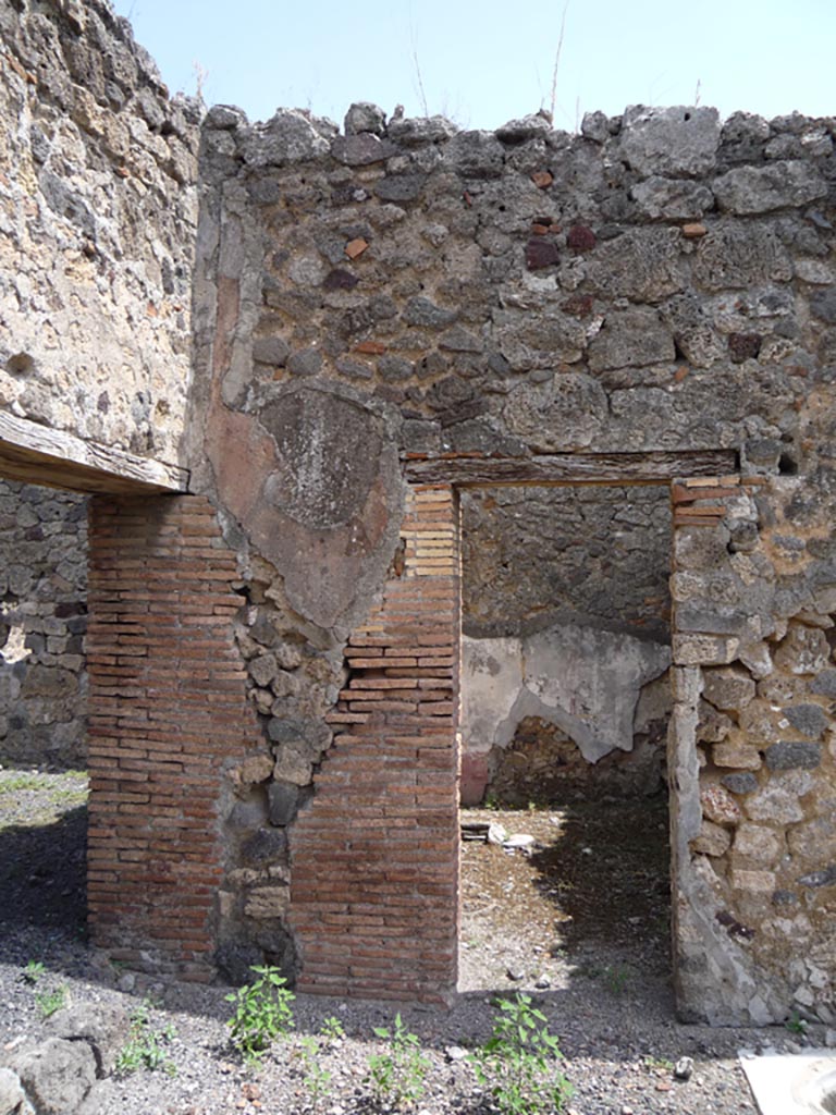 VII.1.36 Pompeii. October 2009. Looking towards doorway in east wall (centre) in north-east corner of atrium.
Photo courtesy of Jared Benton.
According to Breton, opposite the ala was this very pretty room with a lararium.
See Breton, Ernest. 1870. Pompeia, Guide de visite a Pompei, 3rd ed. Paris, Guerin. 
