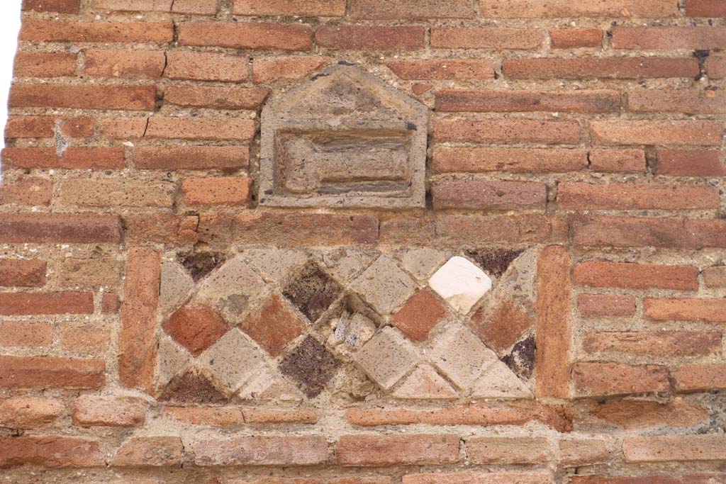 VII.1.36 Pompeii. December 2018. Pilaster on west side of entrance doorway with plaques. Photo courtesy of Aude Durand.