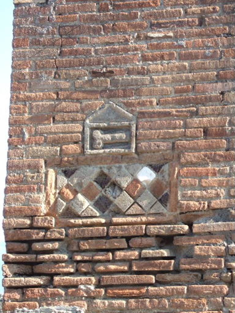 VII.1.36 Pompeii. September 2005. Phallus and rhomboid plaques on pilaster on west side of entrance doorway. 